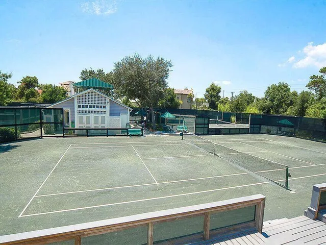 a view of a patio with table and chairs potted plants and large tree