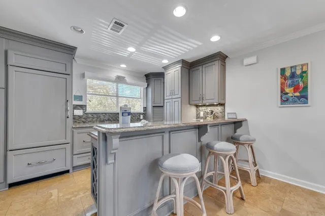 a kitchen with kitchen island granite countertop a sink stove and cabinets