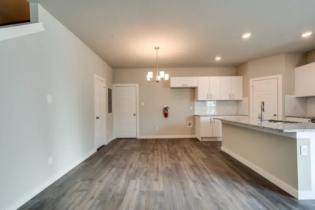 a view of a kitchen with wooden floor and a sink
