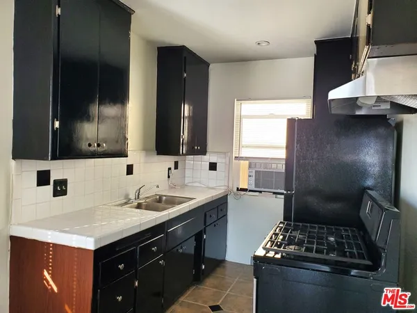 a kitchen with a sink stove and refrigerator