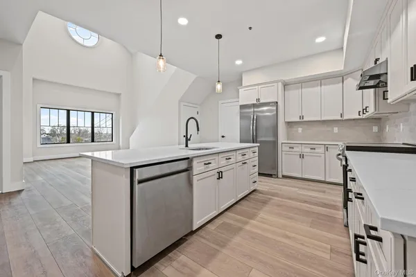 a kitchen with a sink window and stainless steel appliances