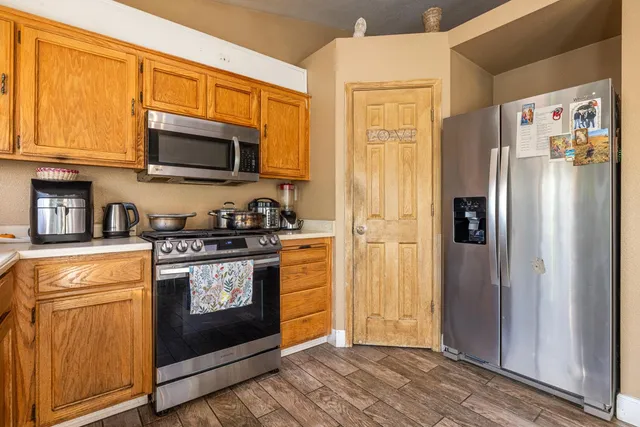 a kitchen with stainless steel appliances granite countertop a refrigerator stove and microwave