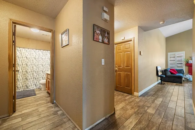 a view of a hallway with wooden floor and closet