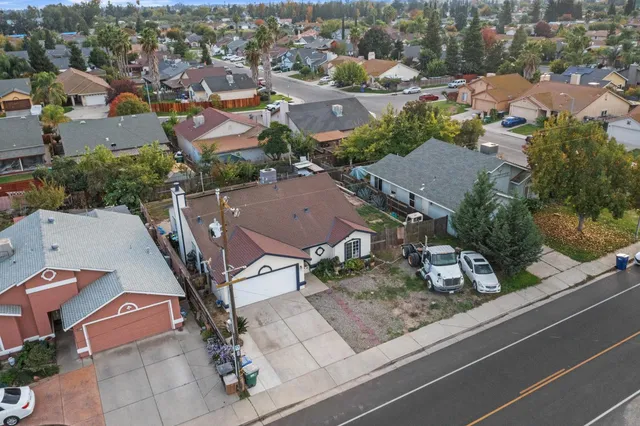 an aerial view of residential houses with outdoor space and parking