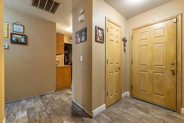 a view of a hallway with wooden floor and closet area