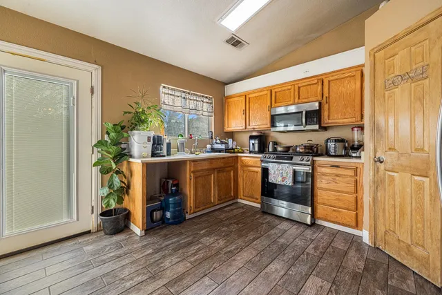 a kitchen with a sink cabinets stainless steel appliances and a window