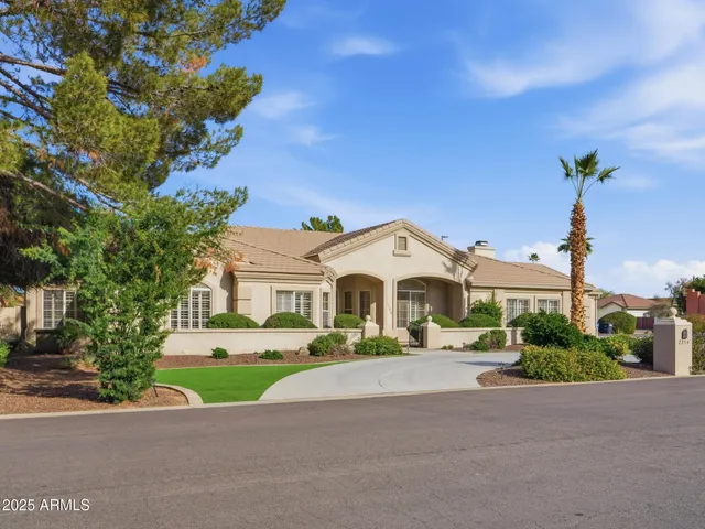 a front view of a house with a yard and potted plants