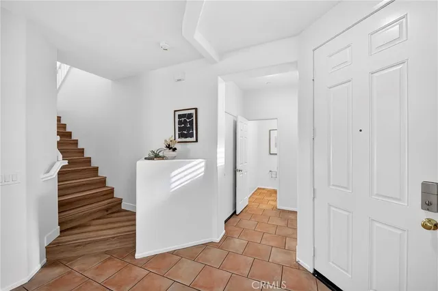 a view of a hallway with entryway and stairs