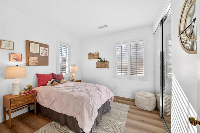 a bedroom with a bed and wooden floor