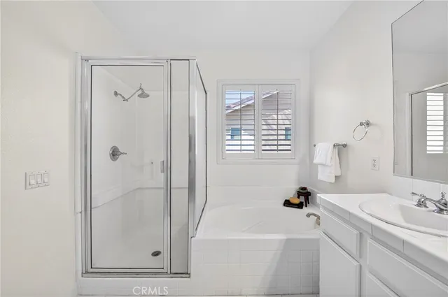 a bathroom with a tub a sink and a window
