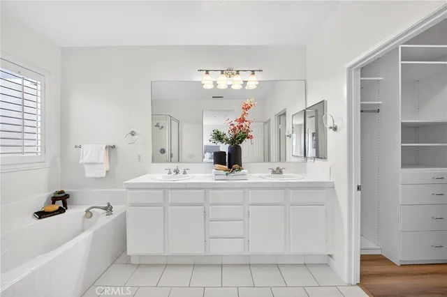 a spacious bathroom with a tub sink and a mirror
