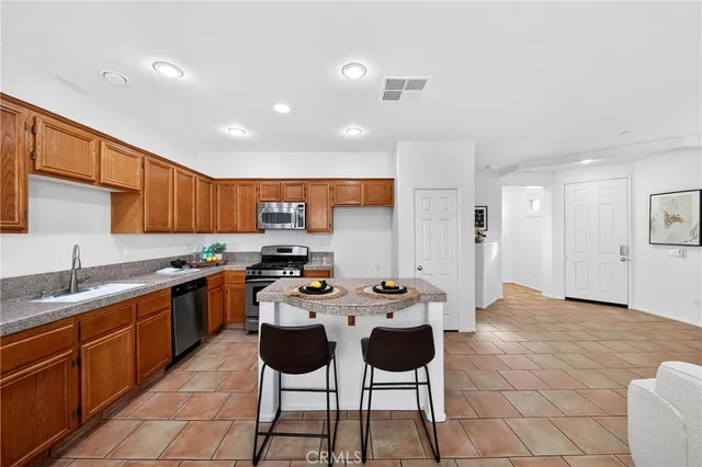 a kitchen with stainless steel appliances kitchen island granite countertop a sink and cabinets
