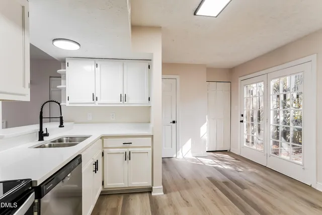 a kitchen with a sink cabinets and wooden floor