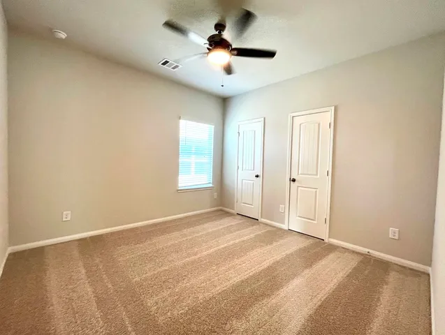 a view of a room with a ceiling fan and window
