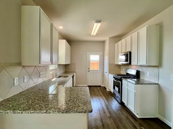 a kitchen with sink cabinets and a wooden floor