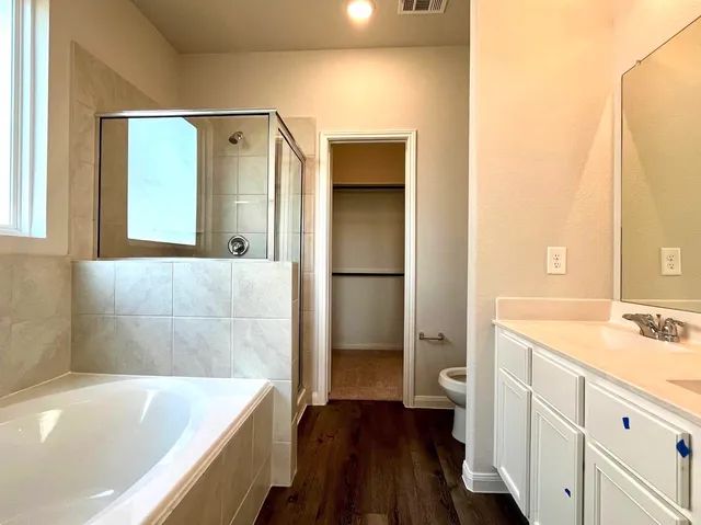 a bathroom with a tub a sink and a large mirror