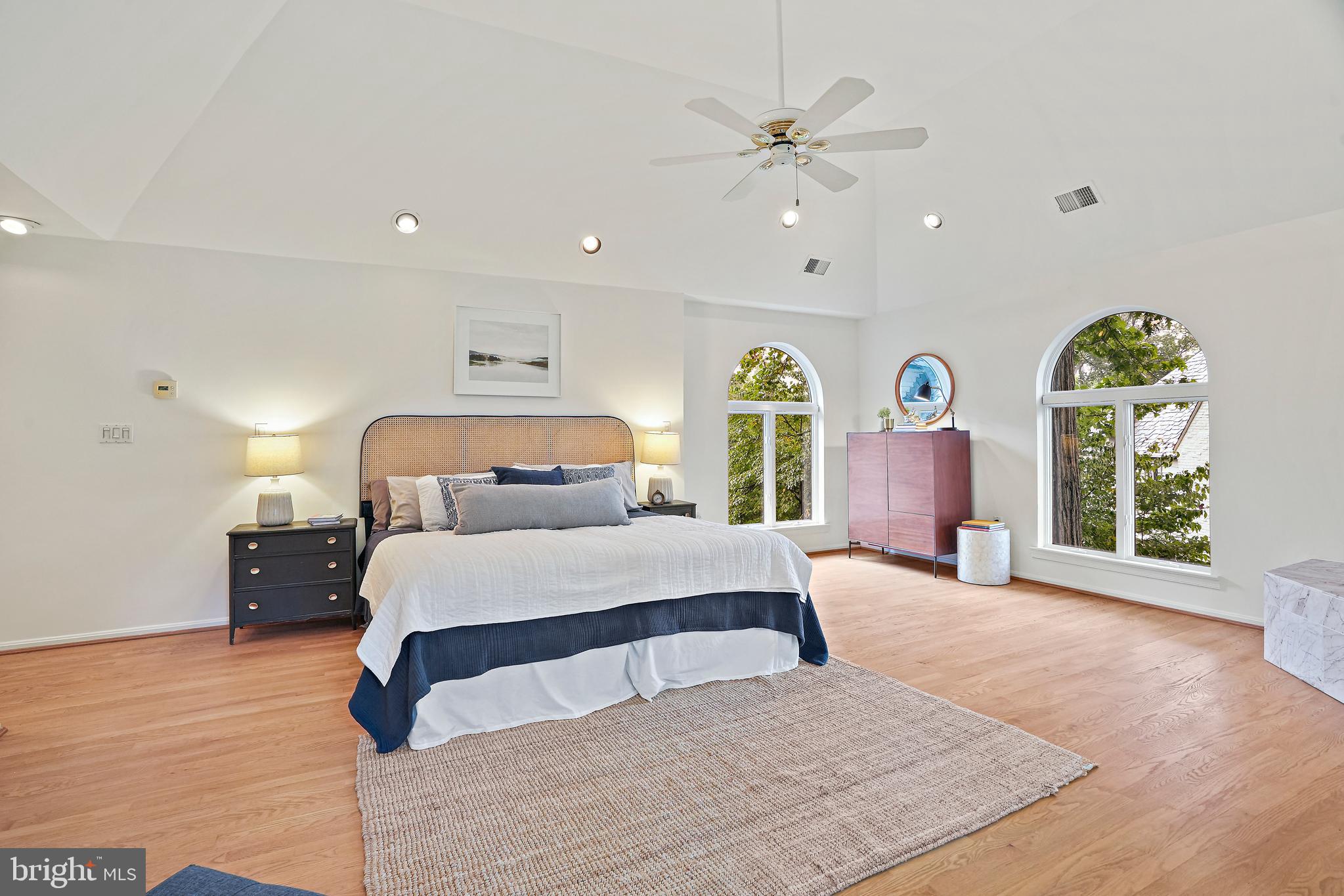 3112 Rolling Road Chevy Chase, MD 20815 - Photo 20 of 38 a spacious bedroom with a large bed and a chandelier