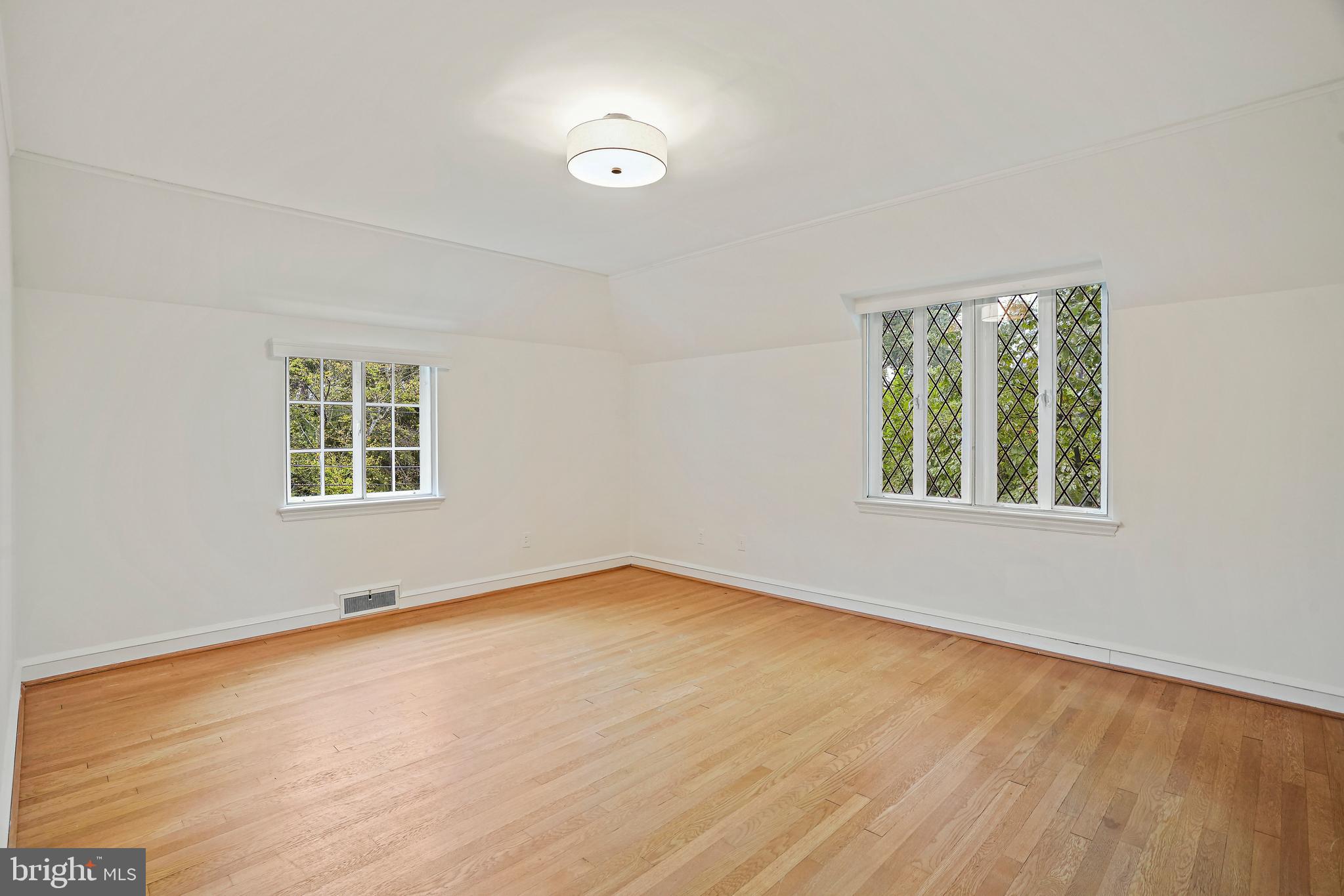 3112 Rolling Road Chevy Chase, MD 20815 - Photo 26 of 38 an empty room with wooden floor and windows