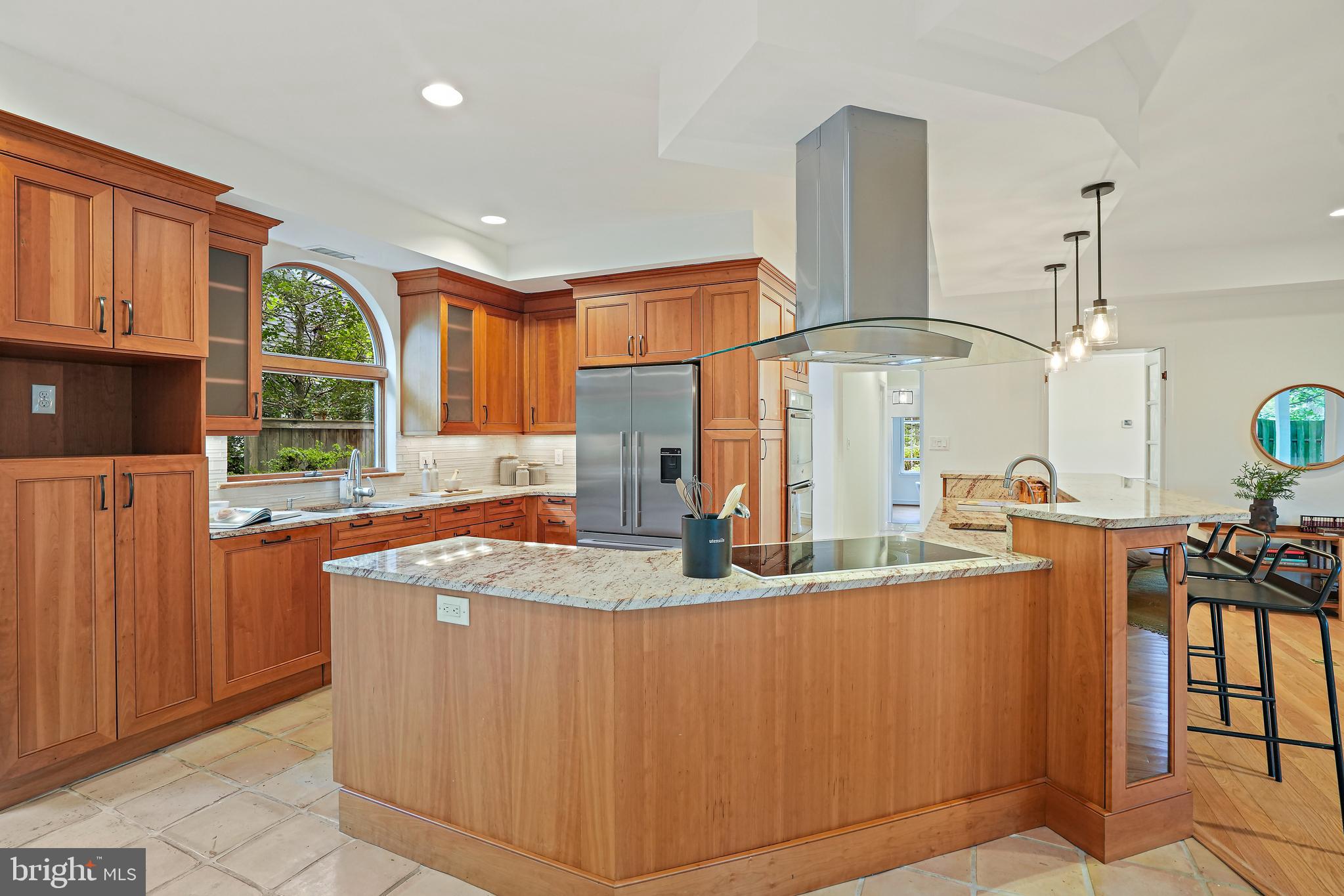 3112 Rolling Road Chevy Chase, MD 20815 - Photo 7 of 38 a kitchen with stainless steel appliances granite countertop a sink a stove and a wooden cabinets