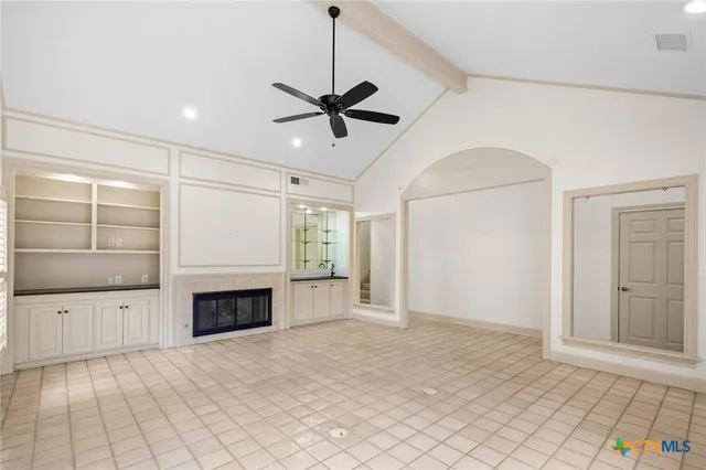 a view of empty room with cabinet and fireplace