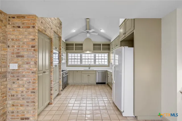 a kitchen with white cabinets and appliances