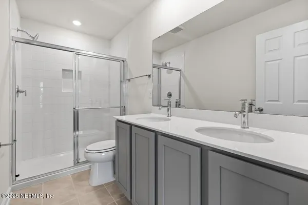 a bathroom with a shower sink vanity mirror and toilet