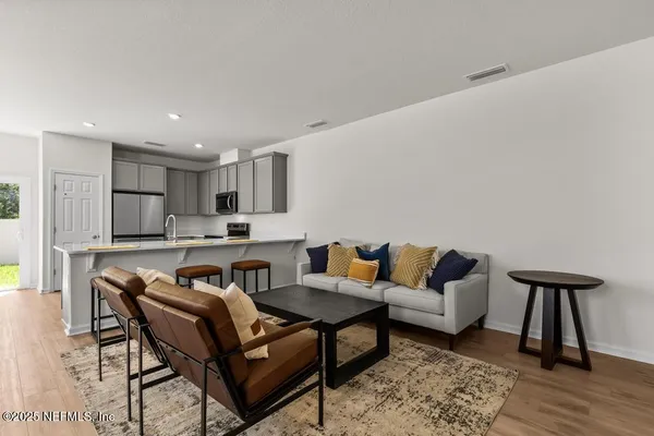 a living room with furniture and a wooden floor