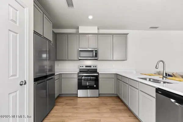 a kitchen with a sink stainless steel appliances and cabinets