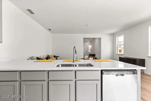a room with a sink a stove and cabinets