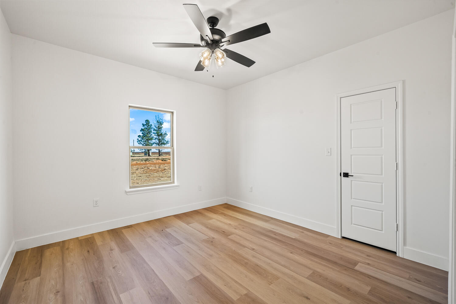 4062 Hawk Road Ropesville, TX 79358 - Photo 28 of 45 an empty room with wooden floor chandelier fan and windows