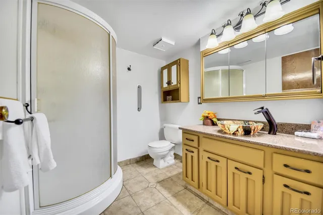 a bathroom with a granite countertop sink toilet and shower