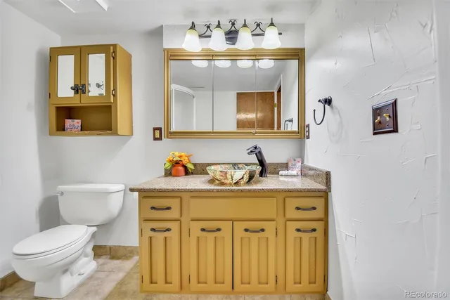 a bathroom with a toilet a sink and mirror