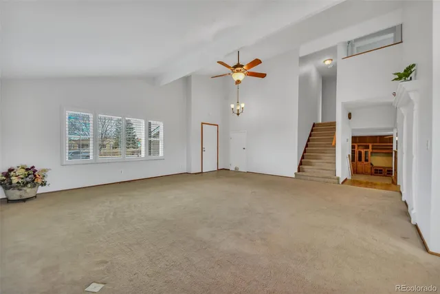 an empty room with windows and fireplace