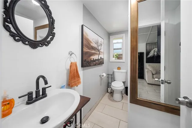 a bathroom with a sink a toilet and a mirror