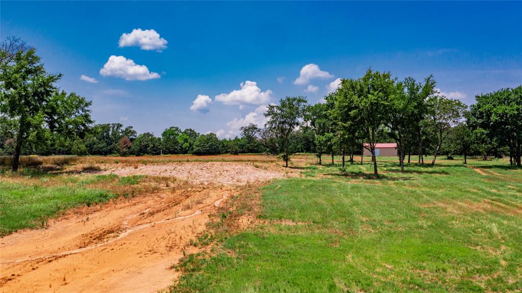 1789 Brumelow Road Whitesboro, TX 76273 - Photo 24 of 30 Expansive rural property featuring a mix of cleared land and mature trees, with a visible outbuilding