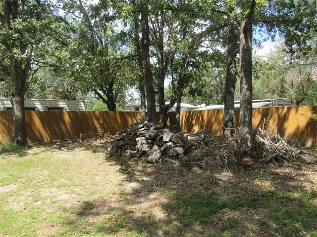 a view of a yard with large trees