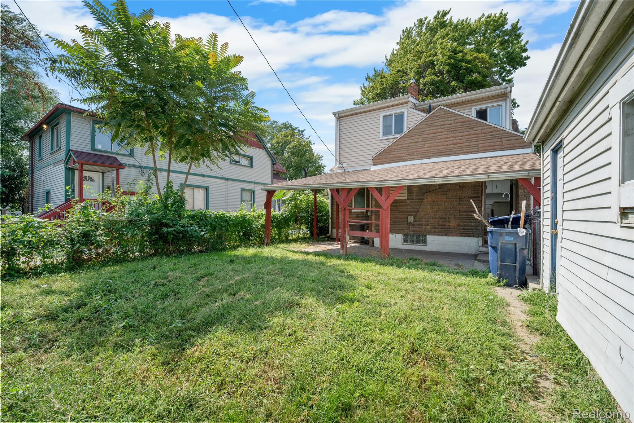 147 Charles Street River Rouge, MI 48218 - Photo 19 of 19 Expansive green space with mature trees and a covered patio area