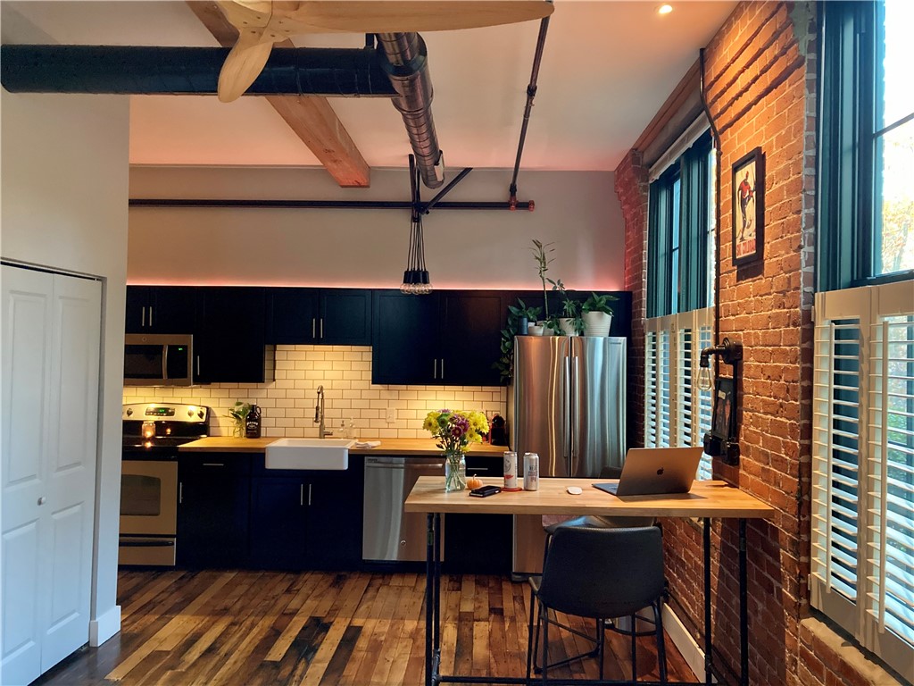 Welcome home to #117, Lofts at Allen Street, a great example of a mill conversion condominium. With 11ft ceilings, exposed brick, huge windows and hardwoods throughout it has a great industrial heritage but is full of modern conveniences with upgrades and updates galore including the subway tile backsplash and the farmers sink.