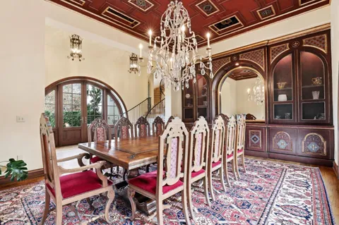 a large white kitchen with a large island in the center and a wooden floors
