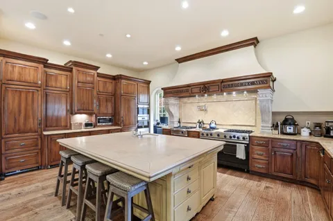 a kitchen with a stove a refrigerator and a kitchen island