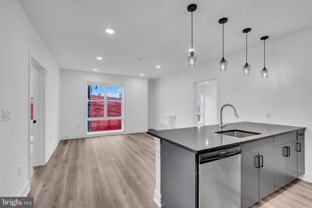 a view of kitchen with a sink wooden floor and window