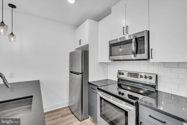 a kitchen with stainless steel appliances a stove microwave and refrigerator