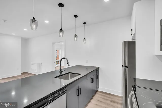 a kitchen with a sink a counter space appliances and cabinets
