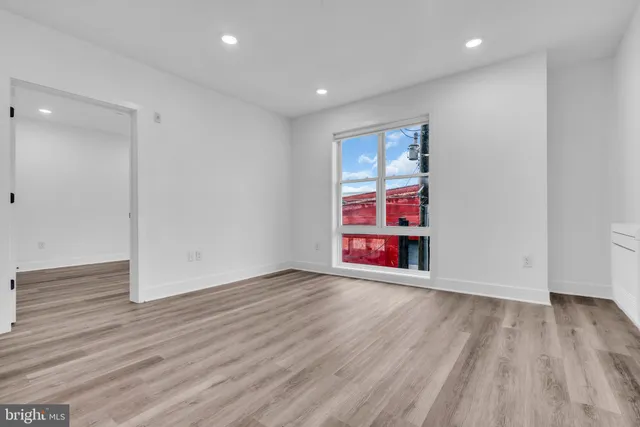 a view of an empty room with wooden floor