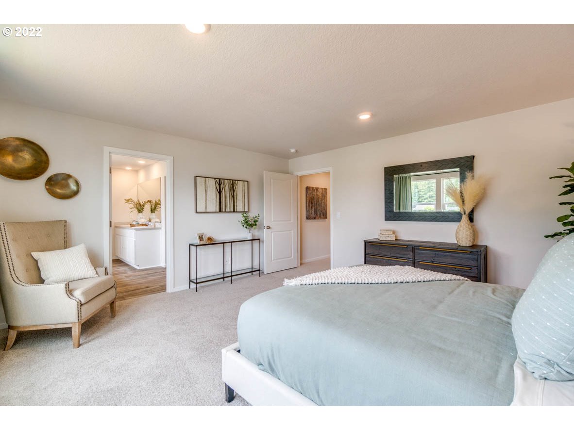 2402 Halter Drive Woodburn, OR 97071 - Photo 30 of 31 a spacious bedroom with a bed a couch and a window