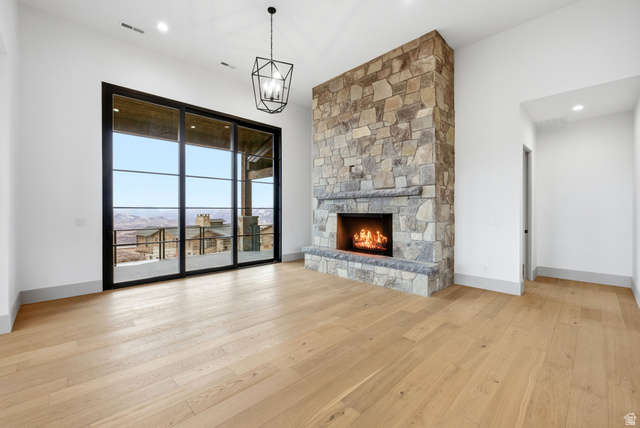 2155 East Wrangler Road Kamas, UT 84036 - Photo 12 of 62 Unfurnished living room with light wood finished floors, a fireplace, and hanging lights