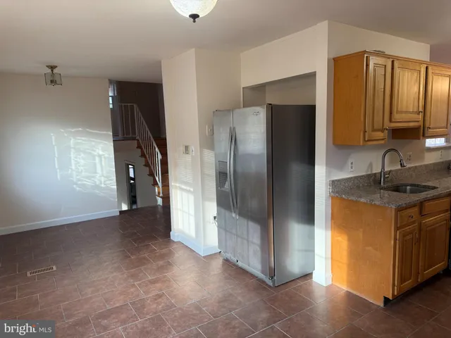 a front view of a building with lots of trees and plants