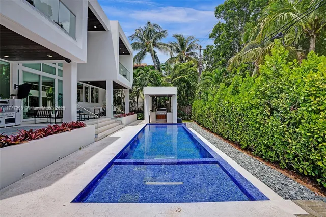 a view of a yard with flower plants and wooden fence