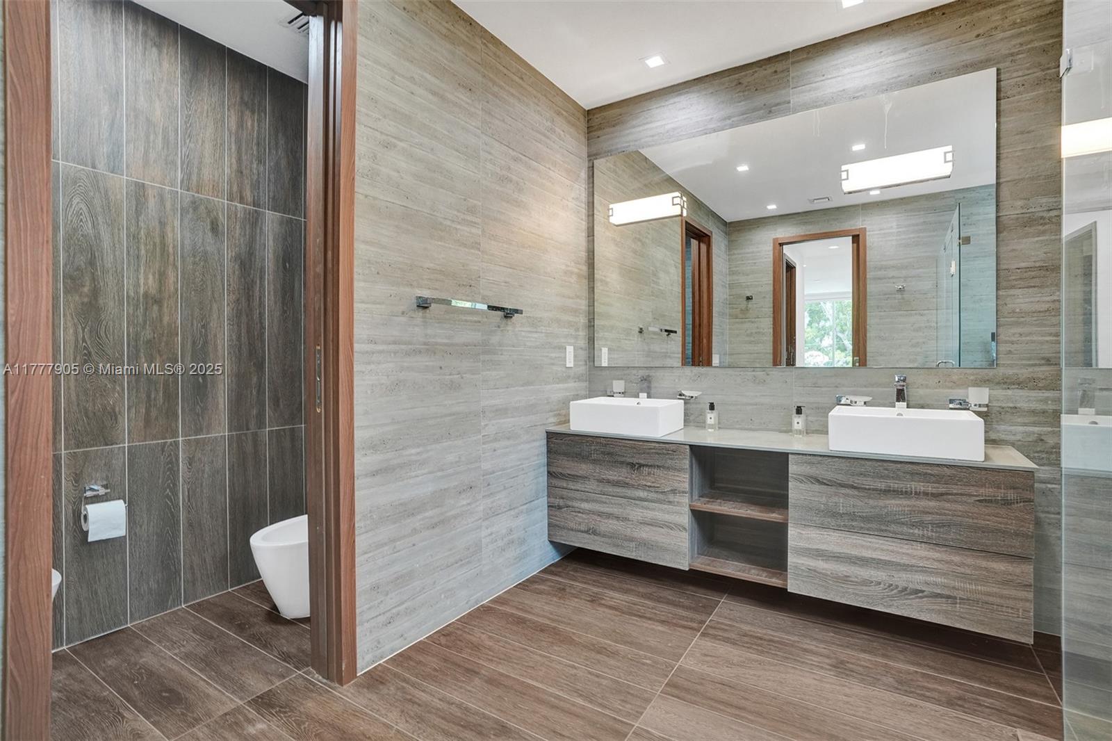 201 Buttonwood Drive Key Biscayne, FL 33149 - Photo 40 of 80 a bathroom with a double vanity sink a toilet and shower