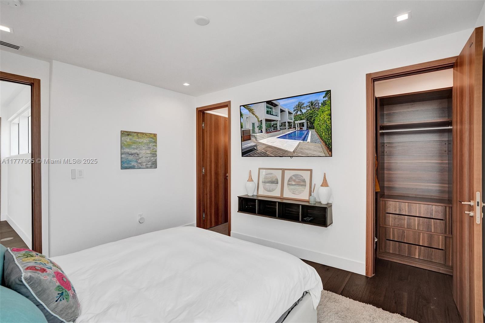 201 Buttonwood Drive Key Biscayne, FL 33149 - Photo 56 of 80 a bedroom with a bed and a flat screen tv